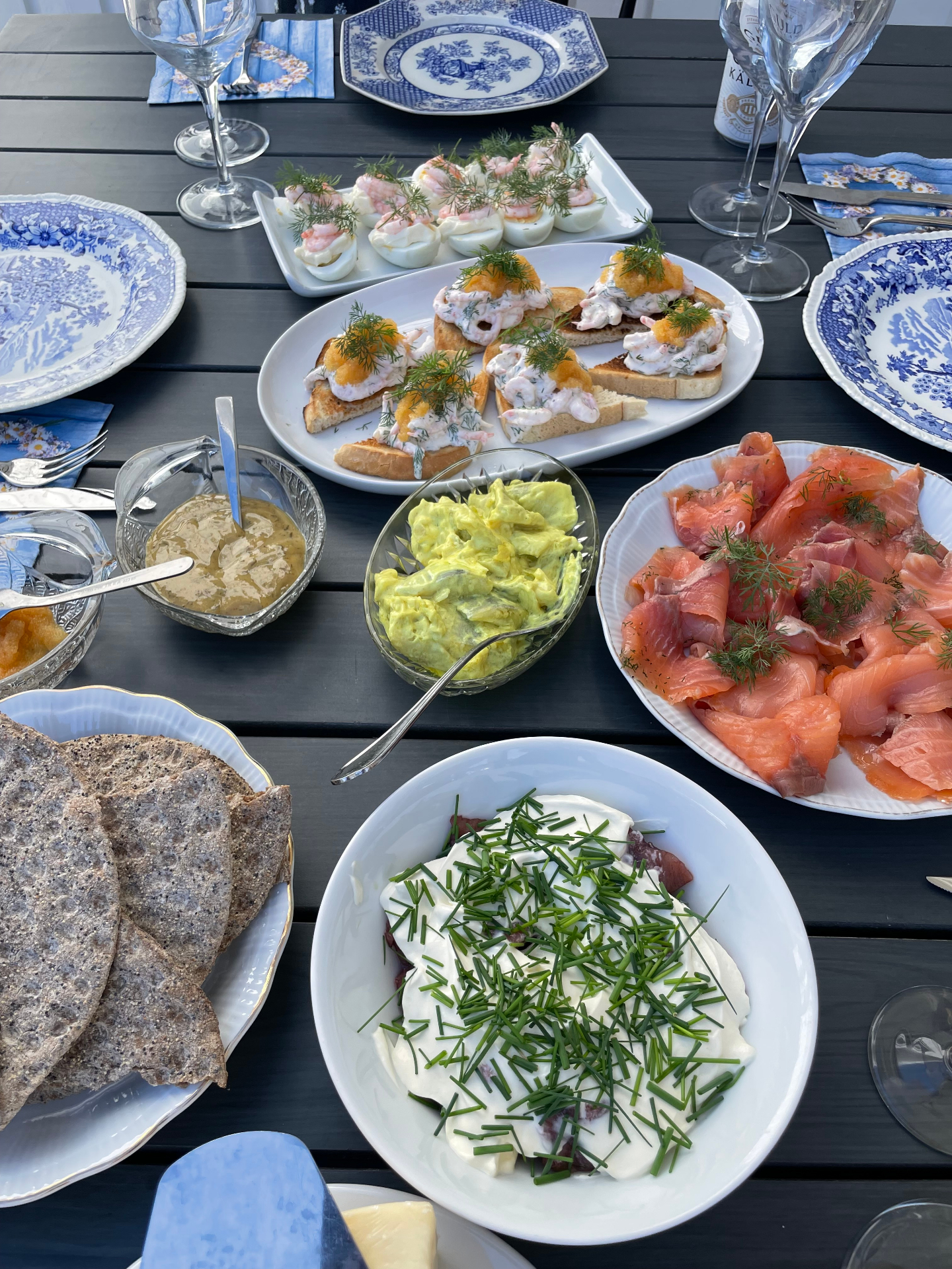 Somriga smörgåsar, lax, såser och råvaror upplagda på ett rustikt bord